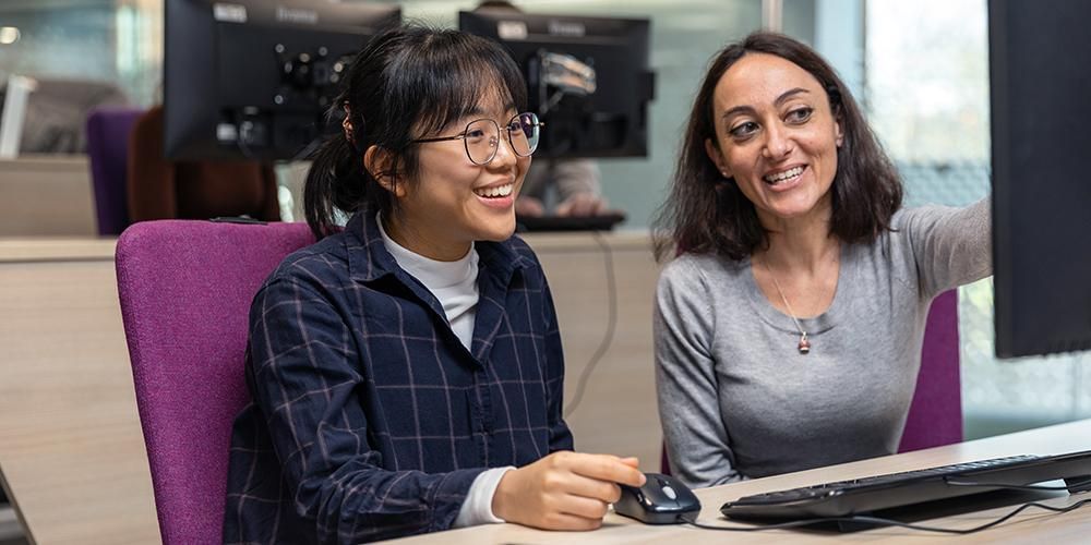 Mentor pointing at a screen advising a student