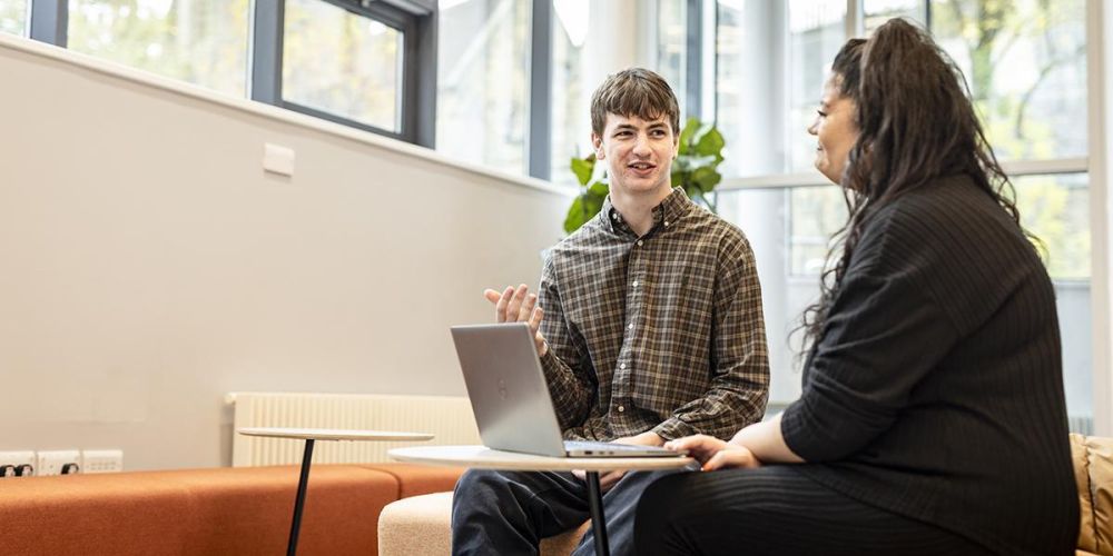 Two people sitting and chatting in student support services
