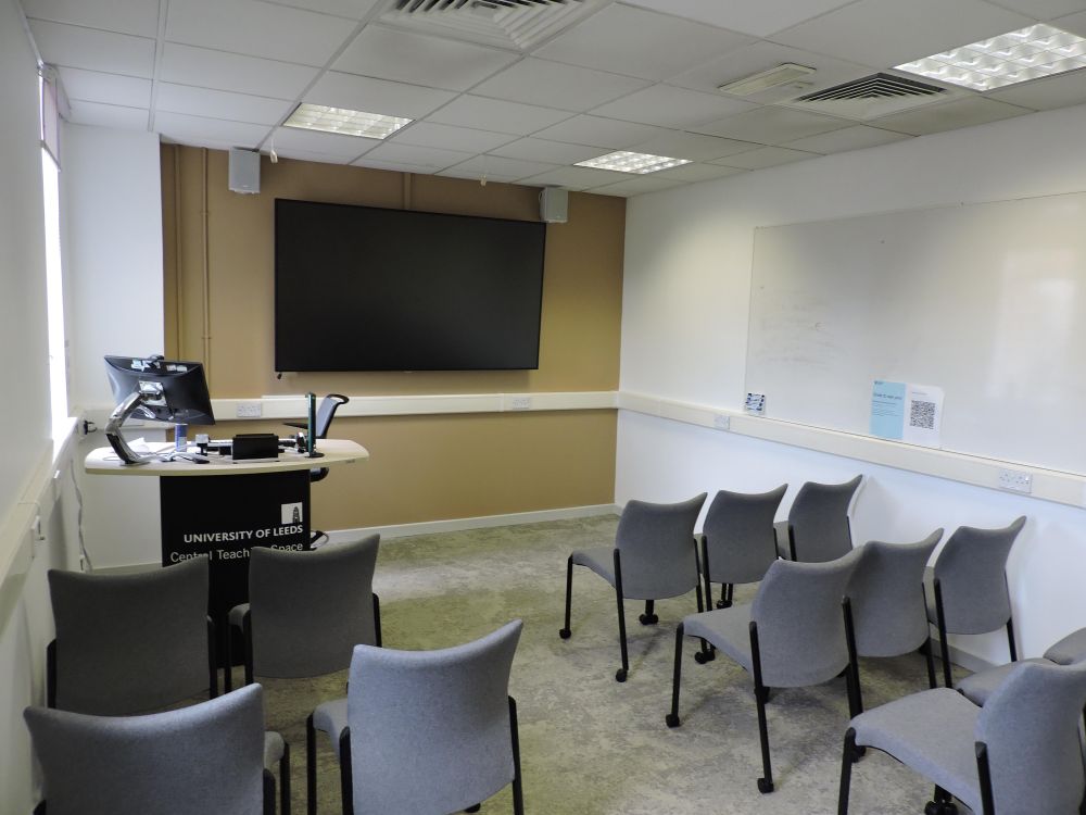 A room with chairs and a screen