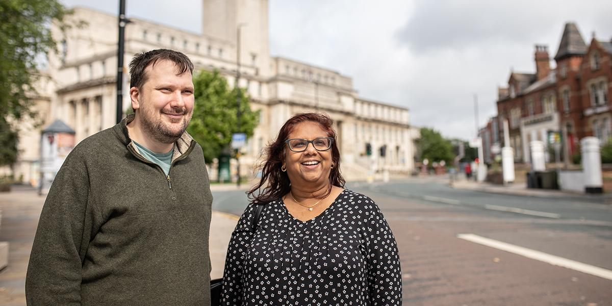 Two mature students standing on Woodhouse Lane with the Parkinson building in the background