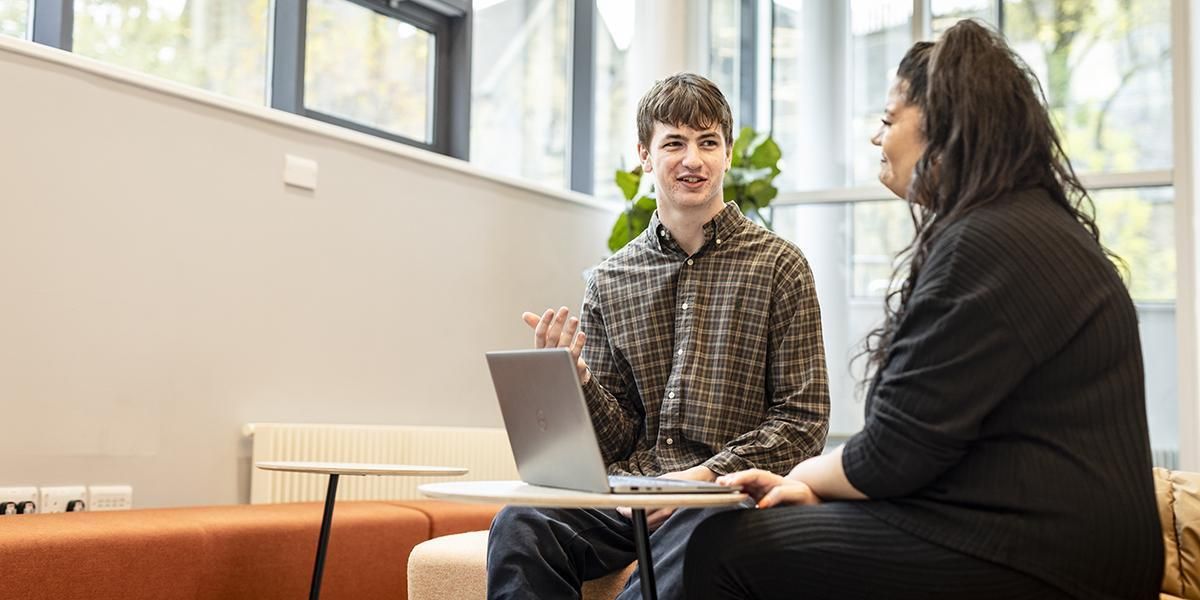 Two people sitting and chatting in student support services