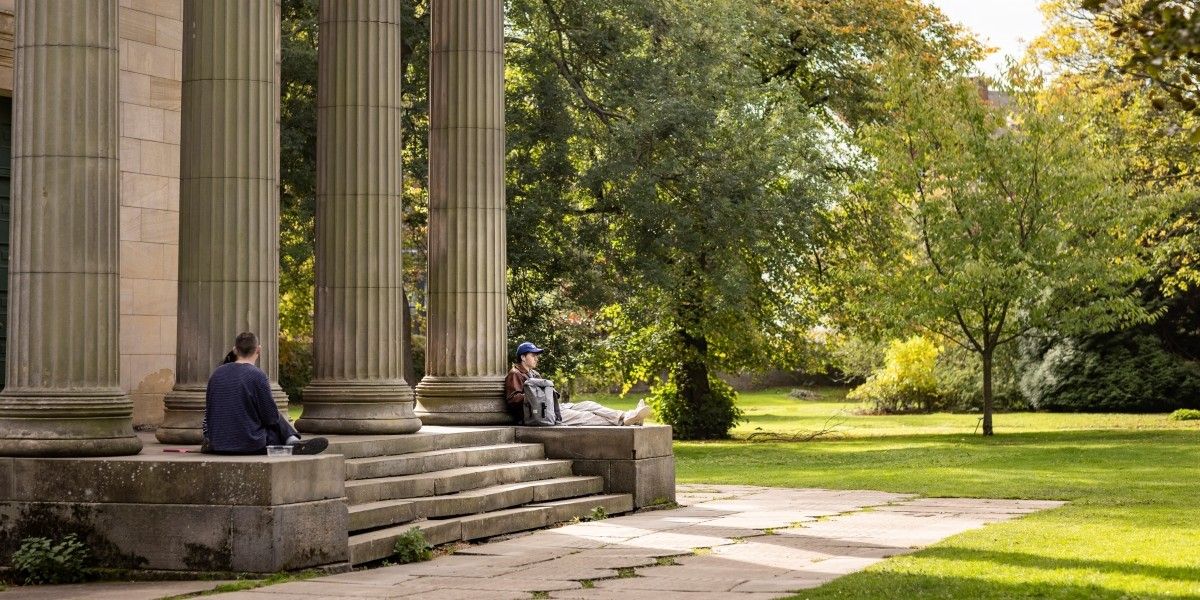 Students sitting outside St Georges Fields' Chapel surrounded by trees