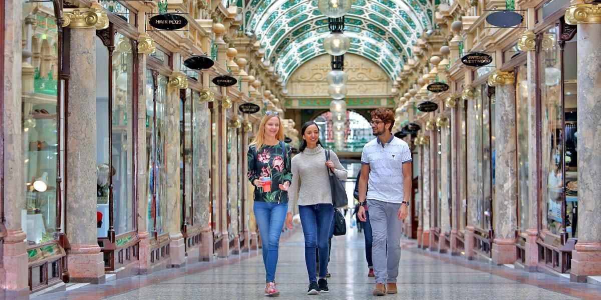 Three students walking in the Victoria Quarter, a shopping centre in Leeds