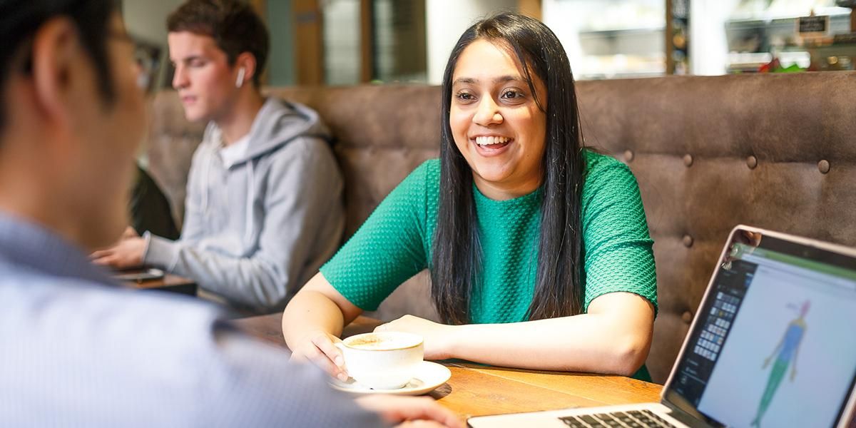 Students in a meeting in cafe with coffee and a laptop