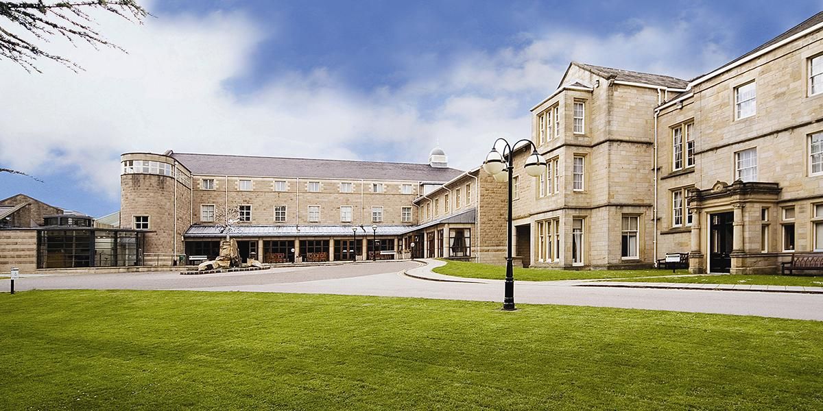 Weetwood Hall building and lawn surrounded by a blue sky