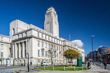 Exterior of the Parkinson building with a tree outside and a blue sky