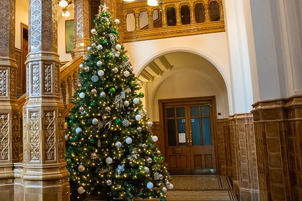 Christmas tree next to grand pillars and a staircase in the Great Hall entrance