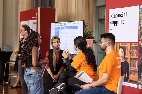 Students and ambassadors chatting at a financial support stand