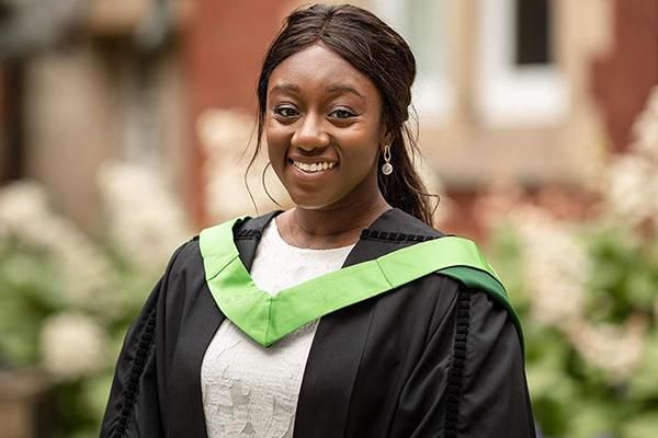 Graduate smiling in a gown on graduation day