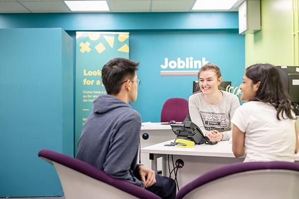 An advisor talking to students at Leeds University Union Joblink