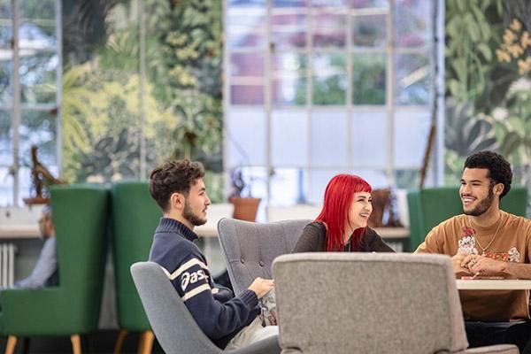 Three students sitting in LUU foyer at a round table