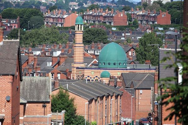 A street scene of Hyde Park showing Leeds Makkah Mosque and houses.
