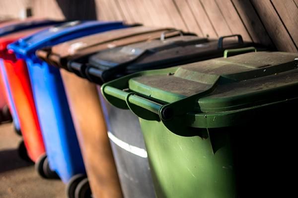 Colourful wheelie bins in a line