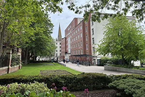 Exterior of the Michael Sadler building surrounded by trees in spring