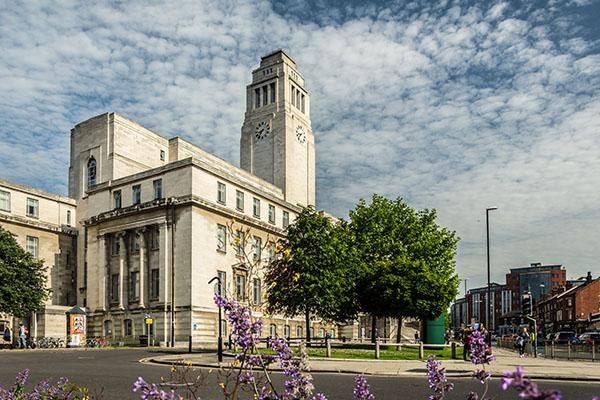 Parkinson building on a sunny day surrounded by clouds and purple flowers