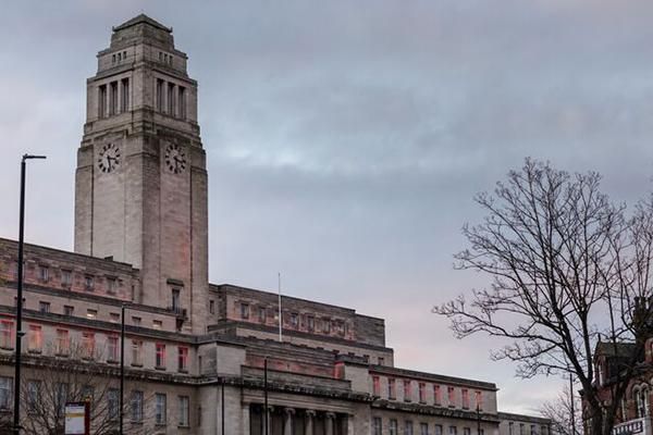 Parkinson Building lit up at winter graduation surrounded by a grey sky and bare tree.