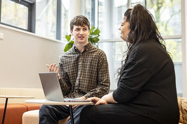 Two people sitting and chatting in student support services