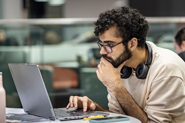 A student looking a laptop screen with a concerned expression.