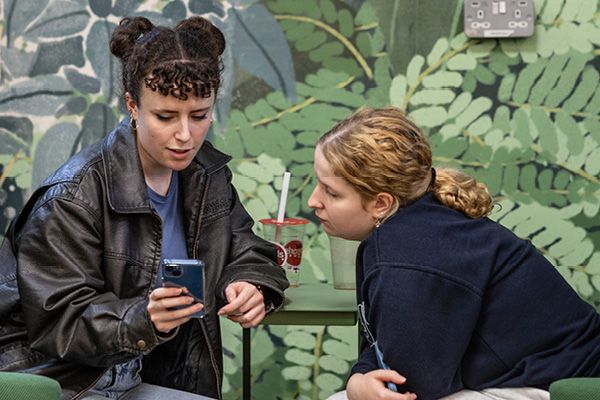 Two students looking at a phone.