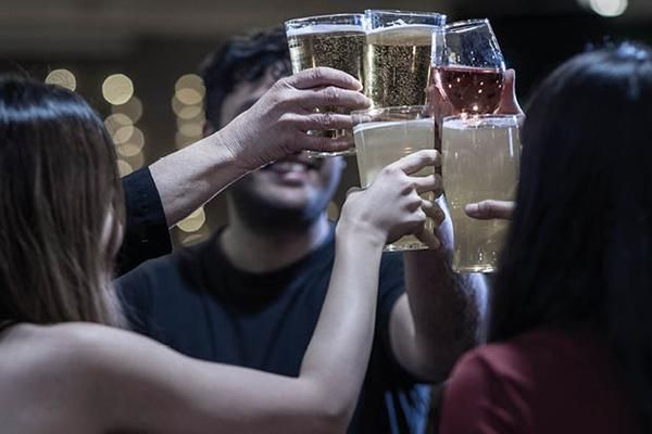 A group of people clinking their glasses together in a circle