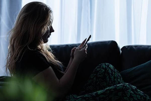 A person sitting on a sofa using their phone