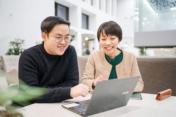 A student and tutor working on a laptop in the Esther Simpson Building café