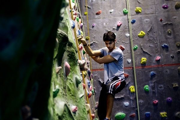 A student using an indoor climbing wall