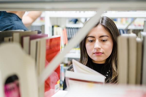 Student selecting a book in a library