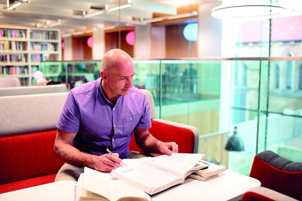 A student studying with their books on a table in Laidlaw Library