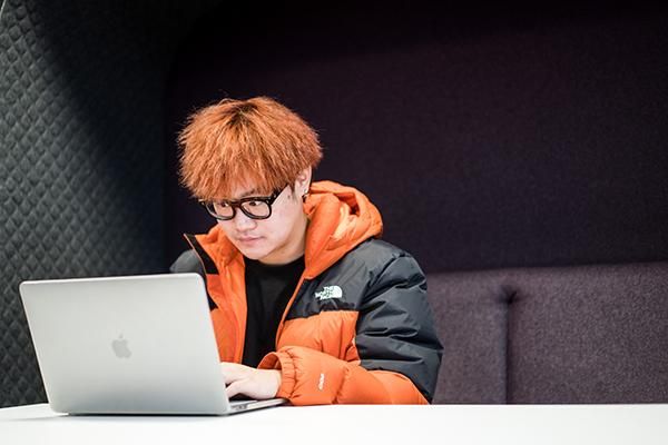 Student working on a laptop in a booth