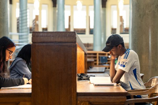 A student reading at a wooden table in the Brotherton Library