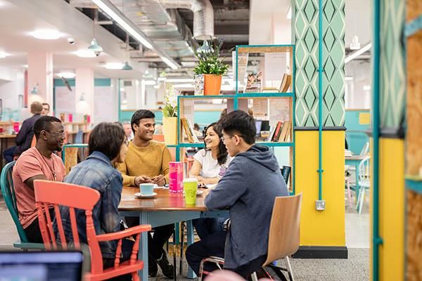 A group of students chatting sitting at a table in LUU