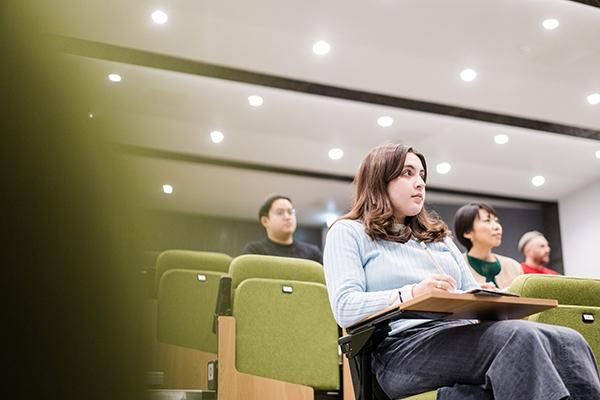 Four students sitting in a lecture theatre