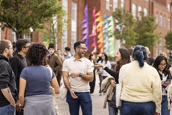 Students laughing in a group at an event outside Leeds University Union