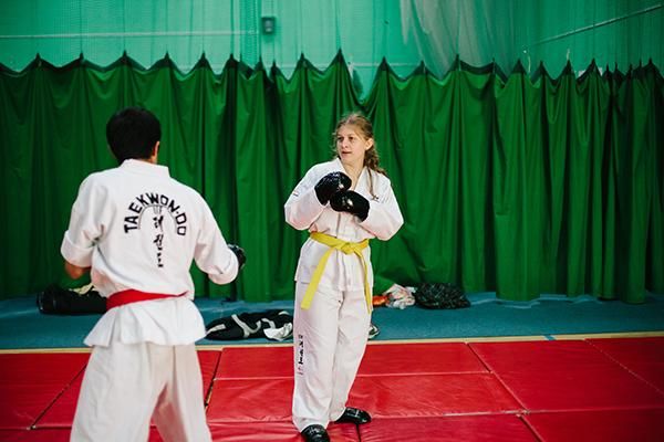 Two members of the Taekwondo society practising Taekwondo on mats