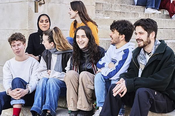 Student action for refugees volunteers sat talking on the Parkinson Building steps