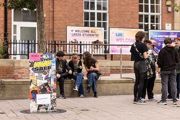 Students sitting on a wall chatting outside LUU during Welcome Week