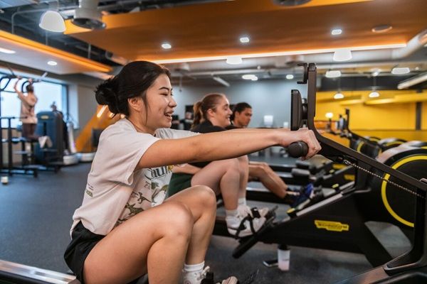 students using rowing machines in the gym