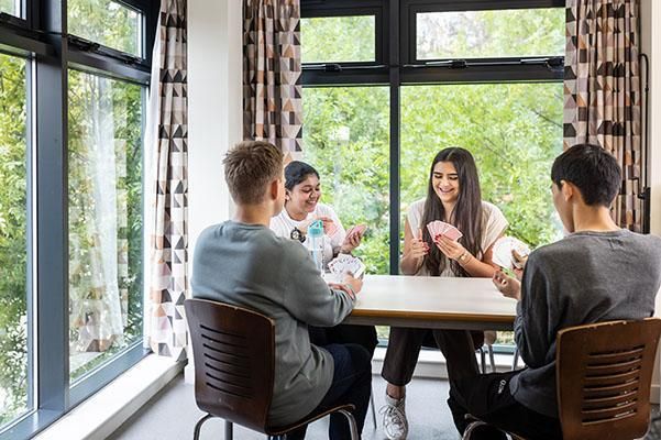 A group of students playing cards in their accommodation