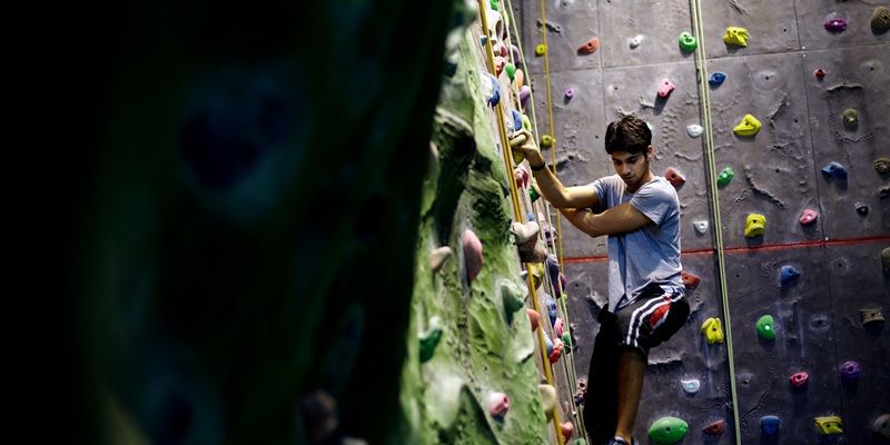 A student using an indoor climbing wall.