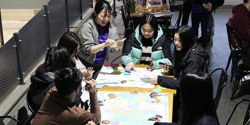 Intercultural ambassadors sat around a table making a map