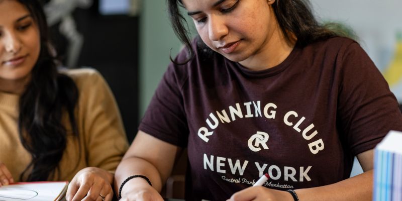 People seated at a table taking part in a creative craft activity.