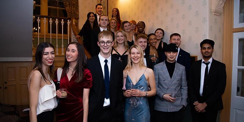 Spark enterprise scholars stand on a staircase at an event