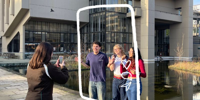 A student filming a trio of students next to the pond outside Roger Stevens building. The trio are framed by a hand-drawn phone screen graphic.