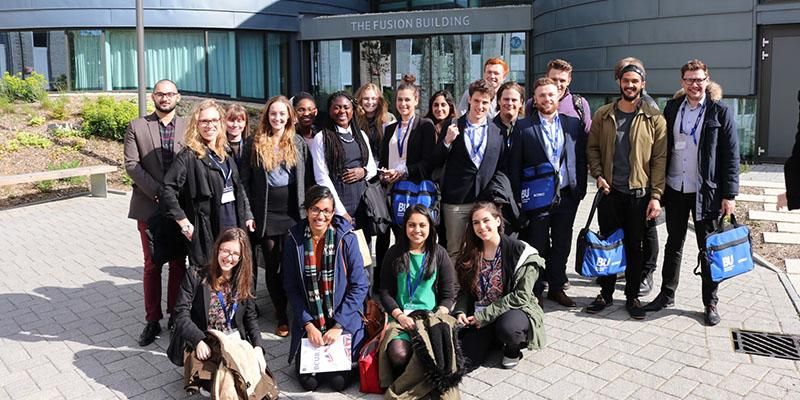 Students in a group outside a building at the British Conference of Undergraduate Research