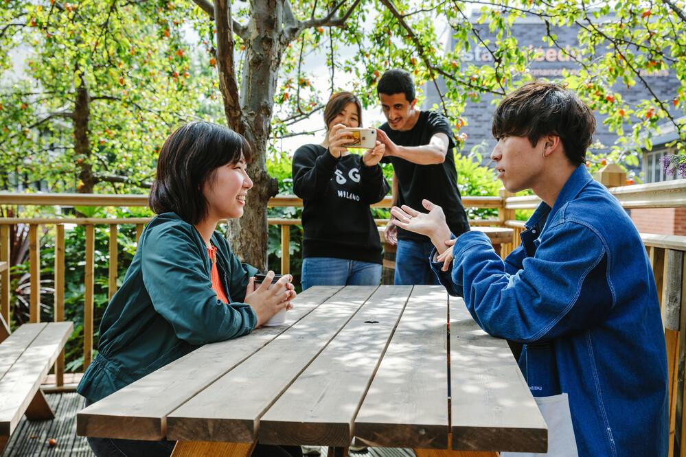 A group of students are sitting at a picnic table