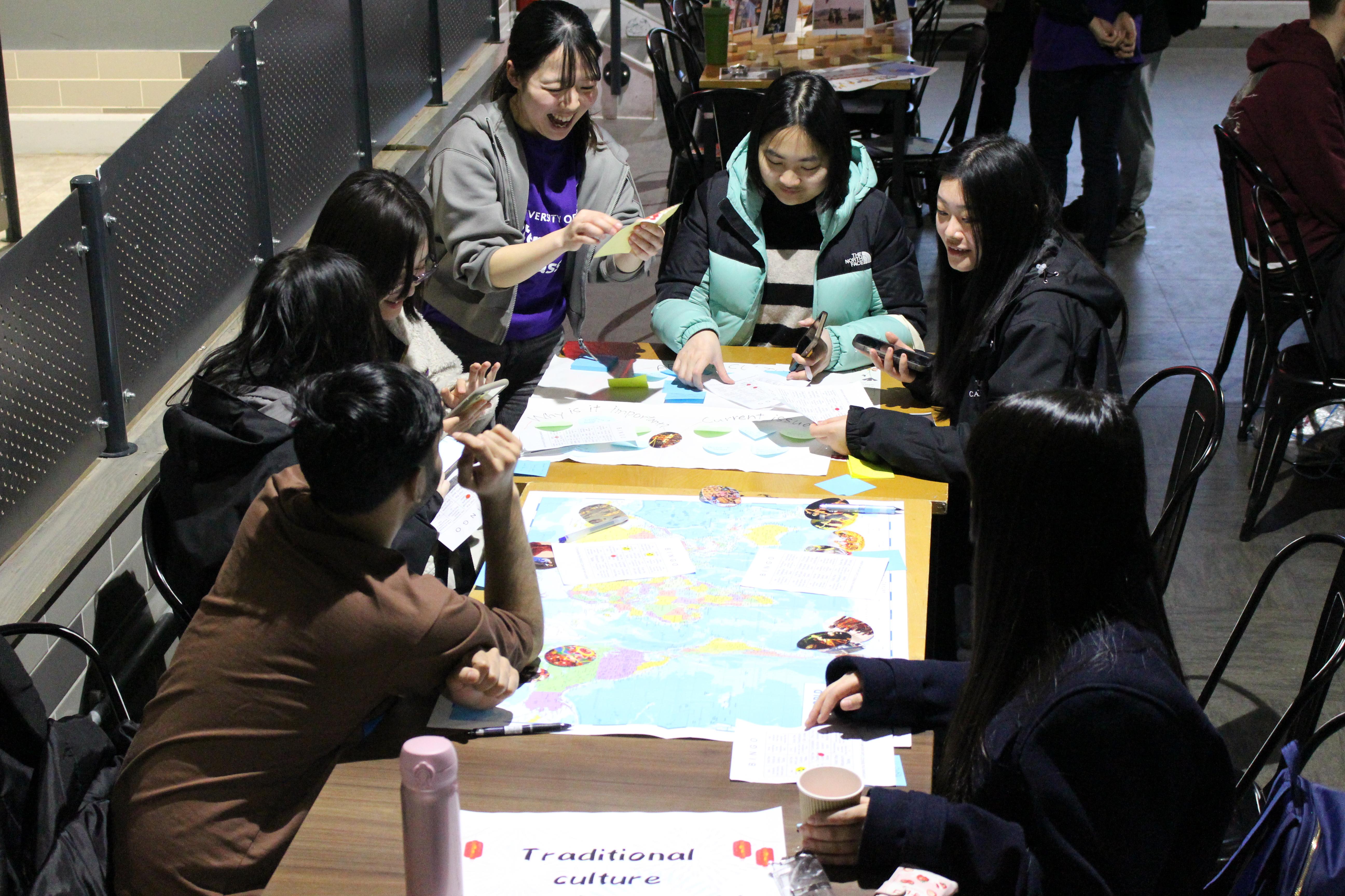 Students sitting around a table looking at a map.